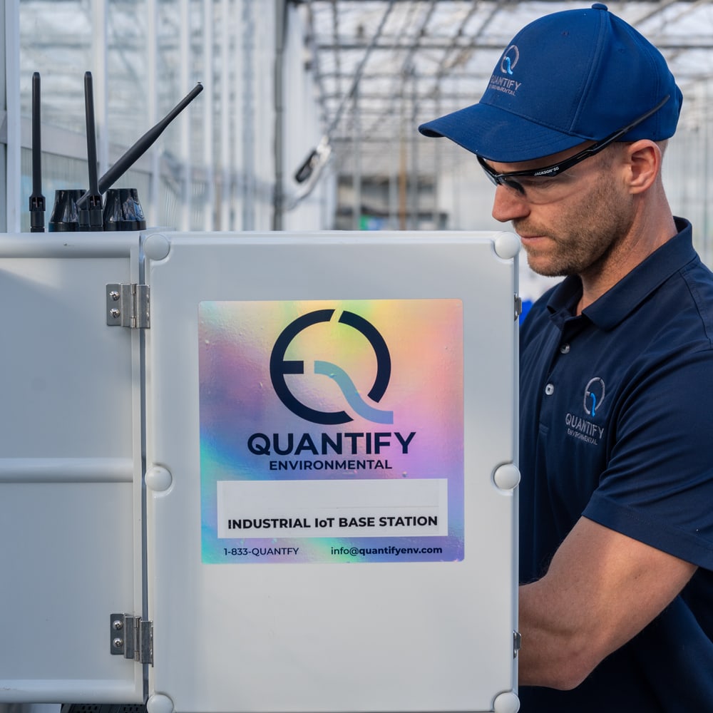 Dave Fox at an open Quantify base station enclosure in a greenhouse