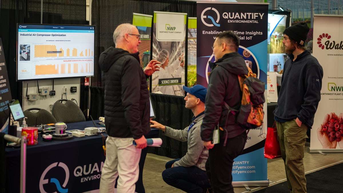 The Quantify booth at the Pacific Agriculture Show, a dashboard on the screen and sensors on the wall